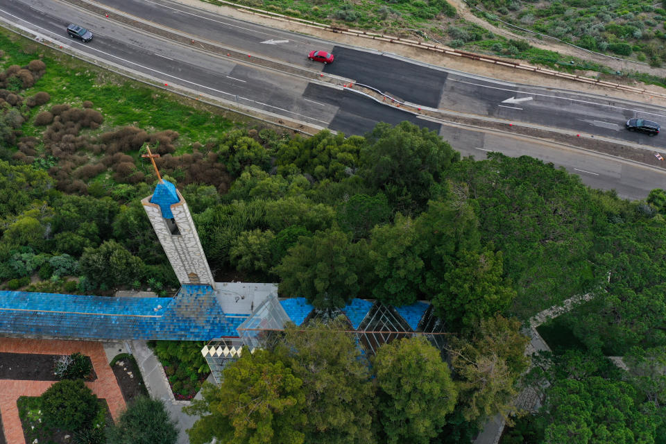 An aerial image shows vehicles driving on a damaged section of Palos Verdes Drive South below the Wayfarers Chapel (Patrick T. Fallon/AFP)