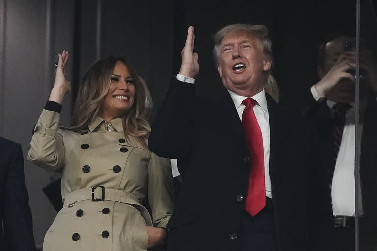 El expresidente estadounidense Donald Trump y su esposa, Melania, realizan el movimiento del "tomahawk chop" antes del cuarto juego de la Serie Mundial entre los Astros de Houston y los Bravos de Atlanta, el sábado 30 de octubre de 2021