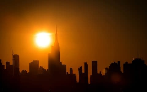 Much of the city, usually illuminated, was plunged into darkness as the sun set - Credit: REUTERS