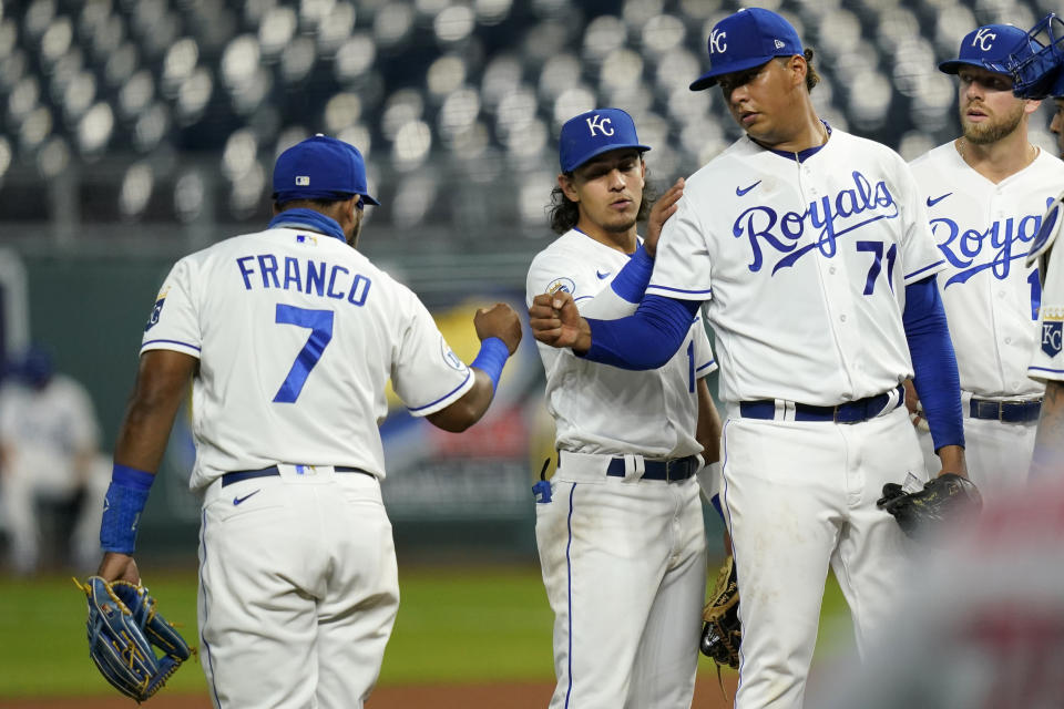 Kansas City Royals starting pitcher Carlos Hernandez (71) fist-bumps third baseman Maikel Franco (7) before leaving in the fourth inning of a baseball game against the St. Louis Cardinals at Kauffman Stadium in Kansas City, Mo., Monday, Sept. 21, 2020. (AP Photo/Orlin Wagner)