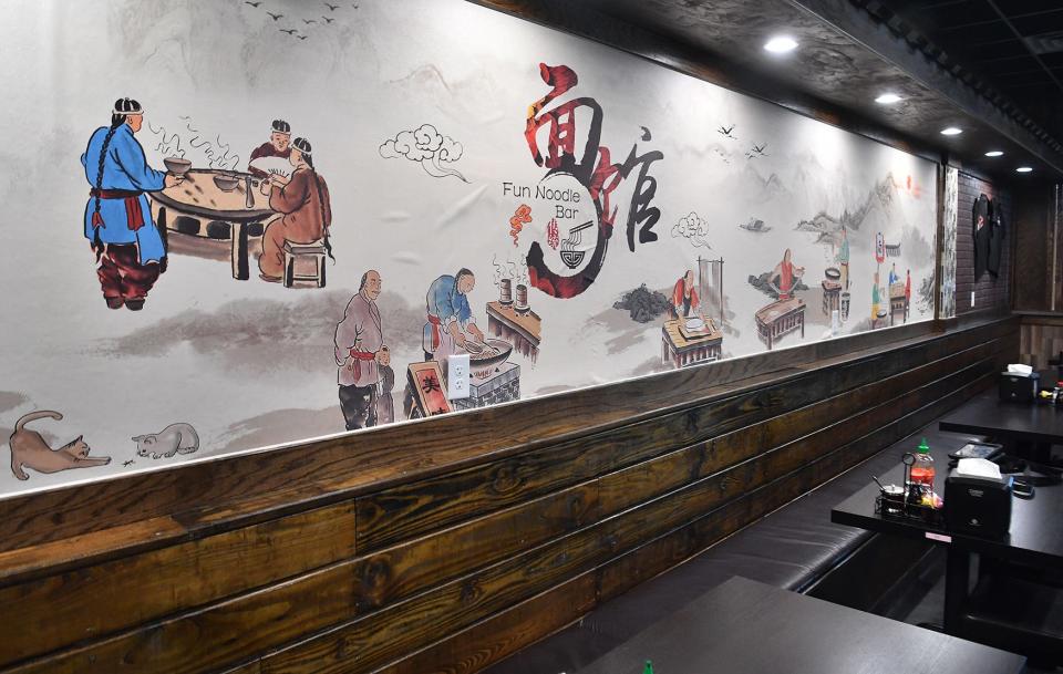 Traditional Asian artwork at Fun Noodle Bar depicts Chinese chefs cooking a variety of foods.