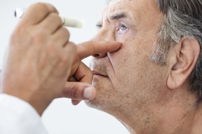 An elderly white male undergoing an eye examination.