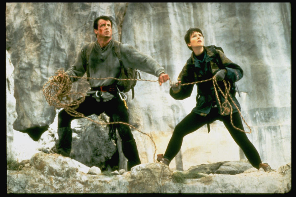 (L-R) Actors Sylvester Stallone & Janine Turner holding rope while standing on mountain ledge in scene fr. action thriller Cliffhanger.  (Photo by John Bryson/The LIFE Images Collection/Getty Images)