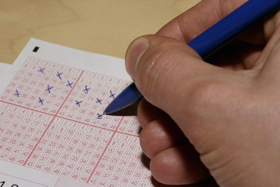 A person filling out a lottery ticket