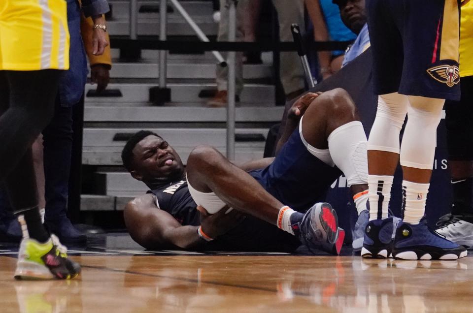 New Orleans Pelicans forward Zion Williamson lies on the ground after going down while driving to the basket in the second half of an NBA basketball game against the Utah Jazz in New Orleans, Sunday, Oct. 23, 2022. Williamson left the game and the Jazz won in overtime 122-121. (AP Photo/Gerald Herbert)