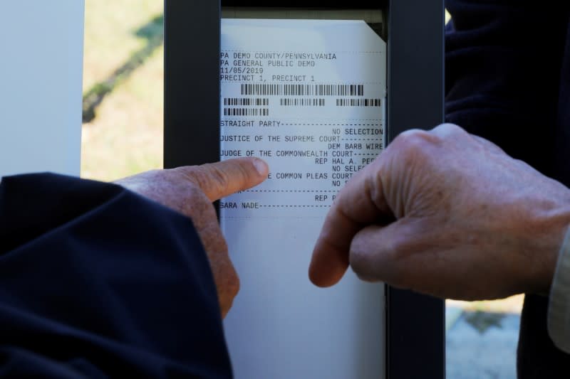 FILE PHOTO: A voter looks at the paper trail created by a new Election Systems & Software ExpressVote XL voting machine in Hanover Township