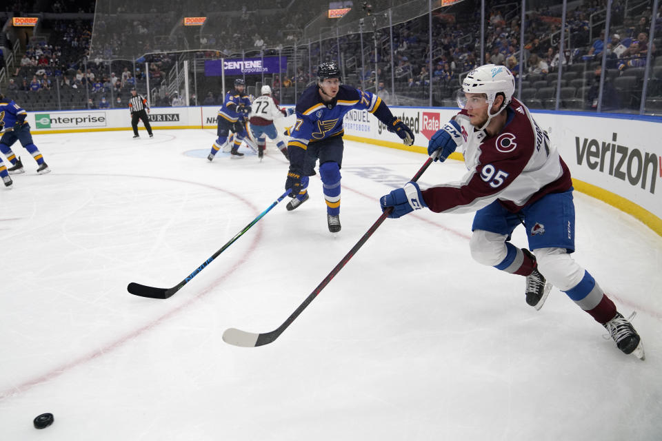 Colorado Avalanche's Andre Burakovsky (95) passes as St. Louis Blues' Niko Mikkola (77) defends during the third period in Game 4 of an NHL hockey Stanley Cup first-round playoff series Sunday, May 23, 2021, in St. Louis. (AP Photo/Jeff Roberson)