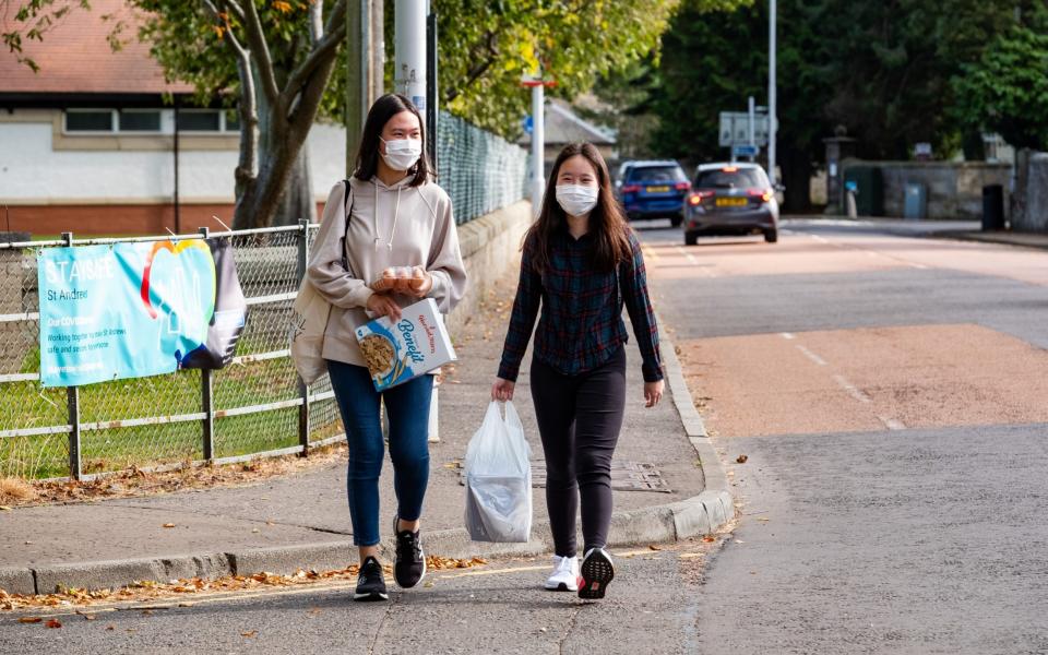 Two students make their way back to University halls of residence after going out to pick up essential food items on Saturday  - Stuart Nicol/Stuart Nicol Photography