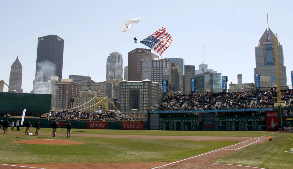 A paratrooper with an American flag descends onto PNC Park during opening day ceremonies before the baseball game between the Pittsburgh Pirates and the Chicago Cubs on Monday, March 31, 2014, in Pittsburgh. (AP Photo/Keith Srakocic)