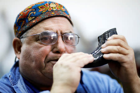 Shofar maker Robert Weinger sounds the Jewish Shofar, a ram's horn, in his workshop in Rishon Lezion, Israel, February 27, 2018. Picture taken February 27, 2018. REUTERS/Amir Cohen