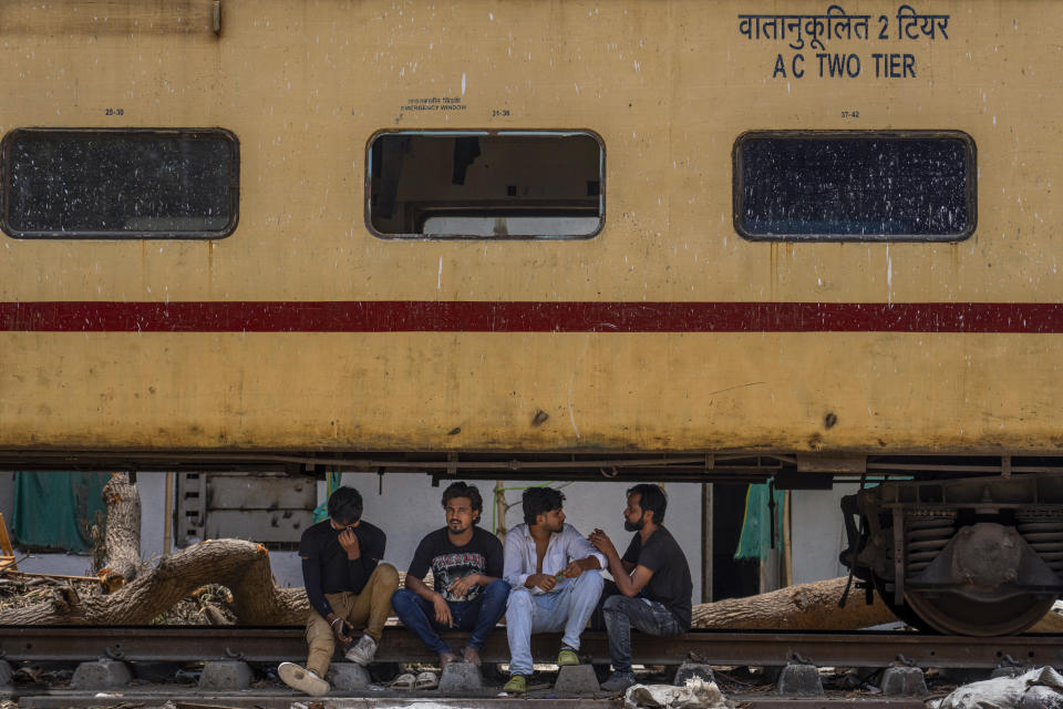 FILE- People rest under a stationary train coach on a hot summer day in Mumbai, India, Thursday, May 30, 2024. A monthslong heat wave across swathes of India has killed more than 100 people and led to over 40,000 suspected cases of heat stroke in the past three and a half months, according to data from India's Health Ministry on Thursday, June 20. (AP Photo/Rafiq Maqbool, File)