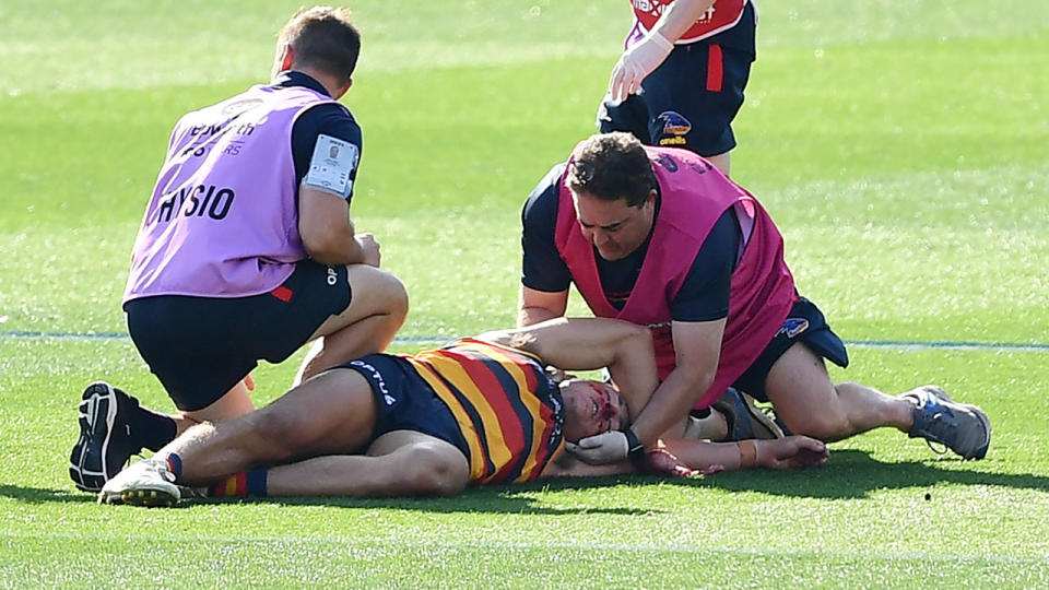 Jake Kelly, pictured here being treated by trainers after his head clash with Patrick Dangerfield.