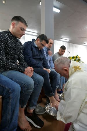 Pope Francis washes feet of an inmate during the celebrations of the Holy Thursday at the District House of Velletri prison, in Velletri near Rome, Italy, April 18, 2019. Vatican Media/­Handout via REUTERS