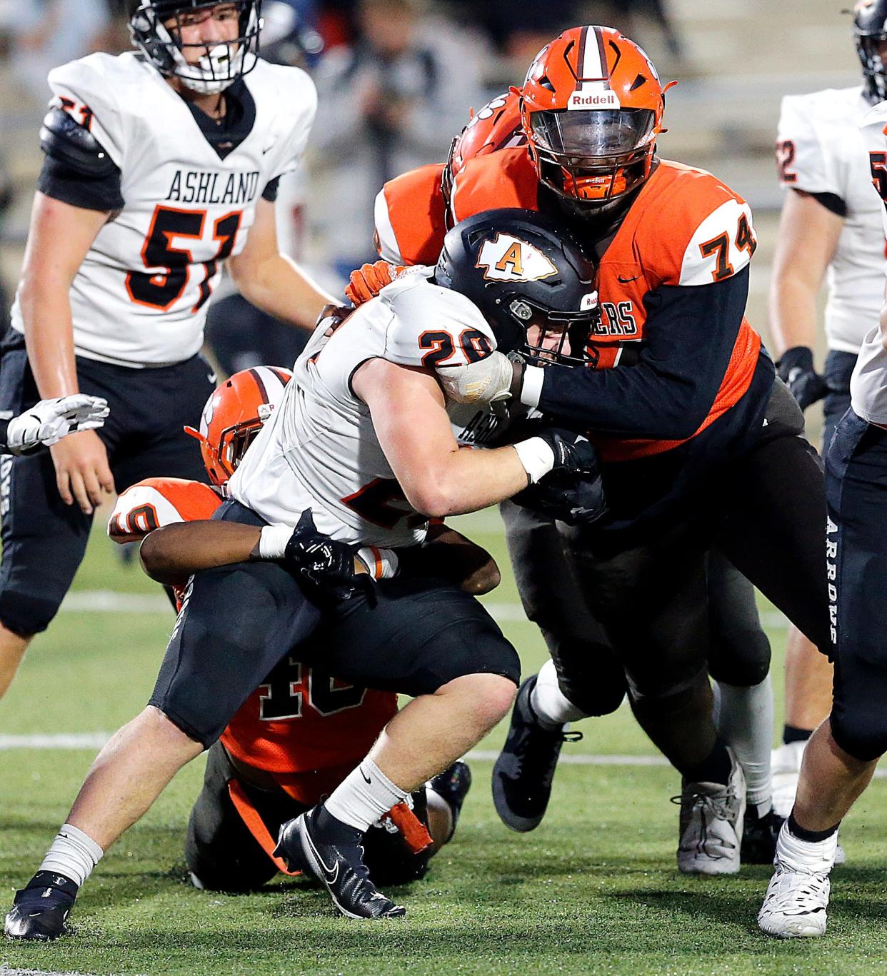 Ashland High School's Cayden Spotts (20) is stopped for a short gain by Mansfield Senior High School's Symirr Phillips (40) and Ahmaan Thomas (74) during high school football action at Arlin Field Friday, Sept. 29, 2023. TOM E. PUSKAR