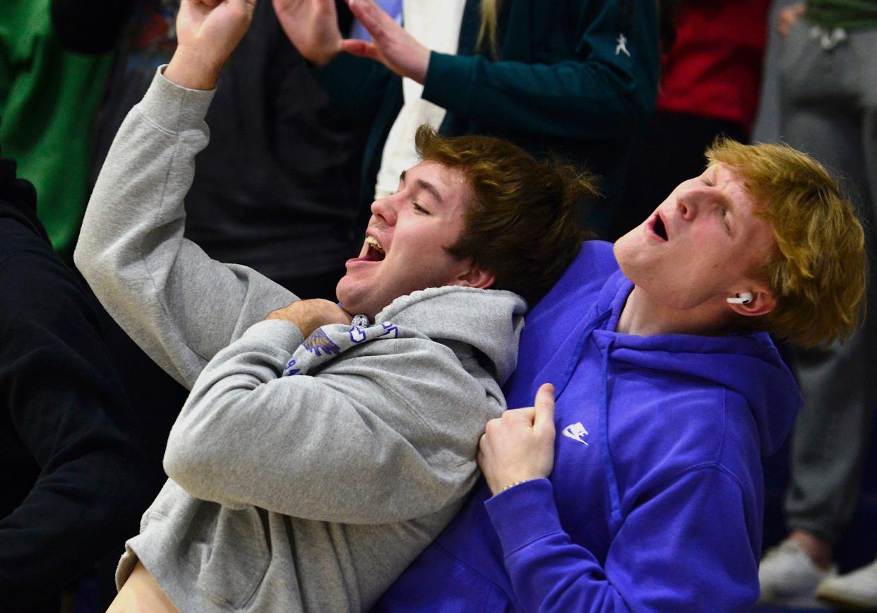 Oklahoma Wesleyan University students (left to right) Matthew Grimm and Brett Roberts react during the OKWU men's basketball 93-48 win over St. Mary recently in Bartlesville.