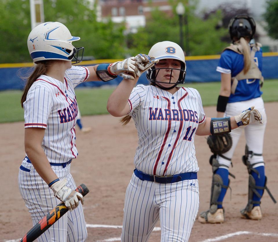 Boonsboro's Sydney Hartle (11) is congratulated by teammate Sage Haller after scoring the Warriors' first run against Walkersville in the CMC Small School championship game.