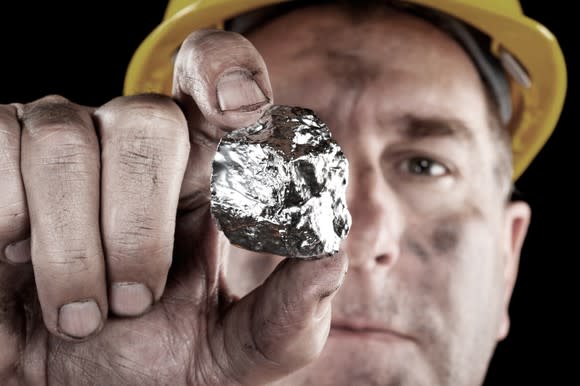 A miner holding a silver nugget