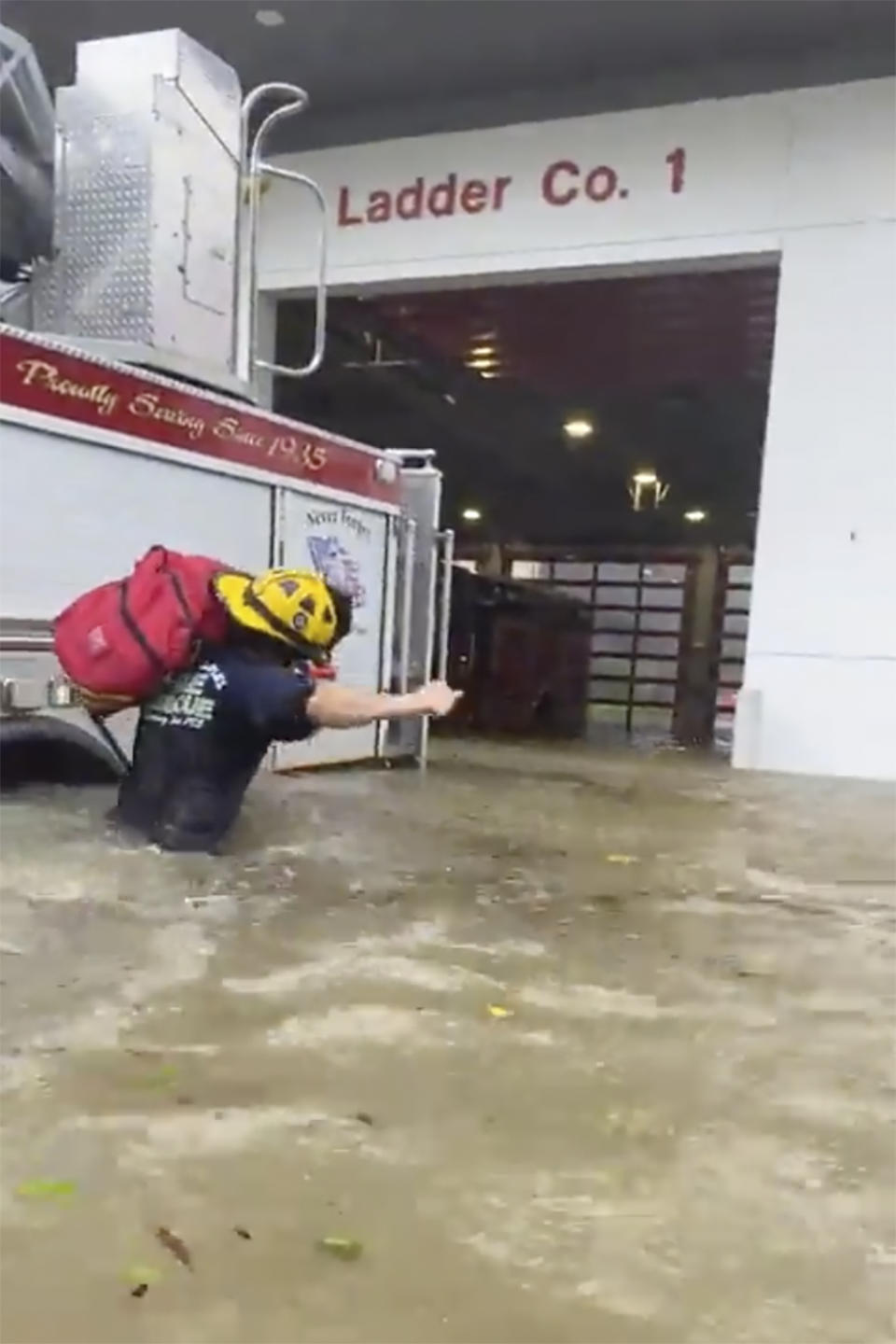 This image provided by the Naples Fire Rescue Department shows a firefighter carrying gear in water from the storm surge from Hurricane Ian on Wednesday, Sept. 28, 2022 in Naples, Fla. Hurricane Ian has made landfall in southwestern Florida as a massive Category 4 storm. (Naples Fire Department via AP)