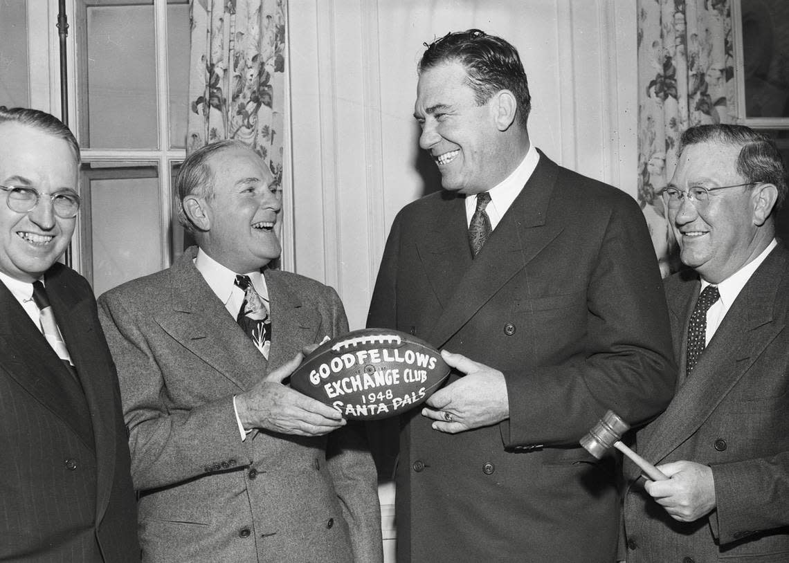 At the Fort Worth Exchange Club Christmas auction, the autographed TCU football brought a total of $2,402.30 in contributions for the Star-Telegram Goodfellow Fund and the Santa Pals. Left to right, Ernest Allen, outgoing president of the Exchange Club; J. Clyde Jones, who won the bid, holds the football; J.A. (Tiny) Gooch, the auctioneer and hands over the football, and Arch H. Rowan, new president of the Exchange Club, holding the gavel. All are in a cheerful spirit. Published on Dec. 22, 1948.