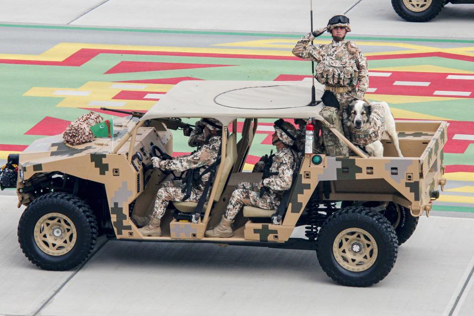 Turkmenistan's army soldiers ride a buggy during a military parade celebrating the country's 30th independence anniversary in Ashgabat, Turkmenistan, Monday, Sept. 27, 2021. The pomp-filled parade took place in Ashgabat, the capital of the gas-rich former Soviet nation in Central Asia. Aside from troops and military equipment, the parade featured employees of state ministries and institutions demonstrating their achievements and Alabai dogs, which accompanied soldiers on military vehicles. (AP Photo/Alexander Vershinin)