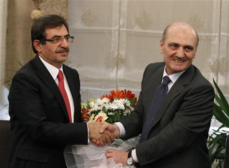 Turkey's newly named Environment and City Planning Minister Idris Gulluce (L) shakes hands with outgoing minister Erdogan Bayraktar during a handover ceremony in Ankara December 26, 2013. REUTERS/Umit Bektas