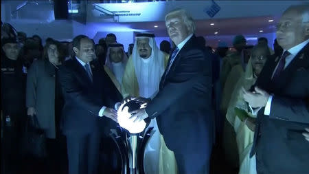 U.S. President Donald Trump places his hands on a glowing orb as he tours with other leaders the Global Center for Combatting Extremist Ideology in Riyadh, Saudi Arabia May 21, 2017. Saudi TV via Reuters