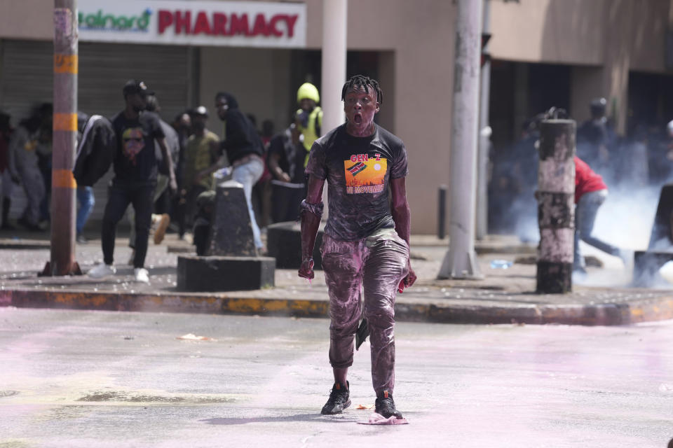 A protester gestures as Kenya police spray water canon during a protest over proposed tax hikes in a finance bill in downtown Nairobi, Kenya, Tuesday, June 25, 2024. (AP Photo/Brian Inganga)