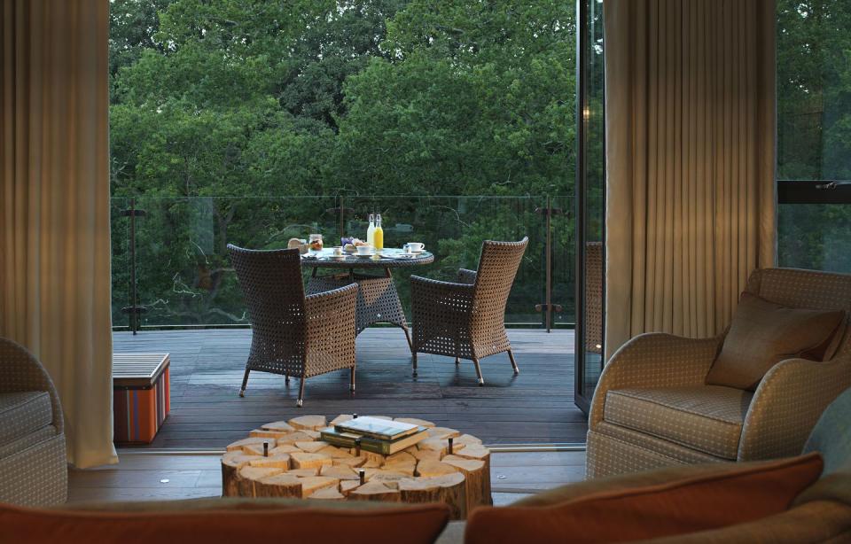 a living room with a table and chairs in the chewton glen treehouse