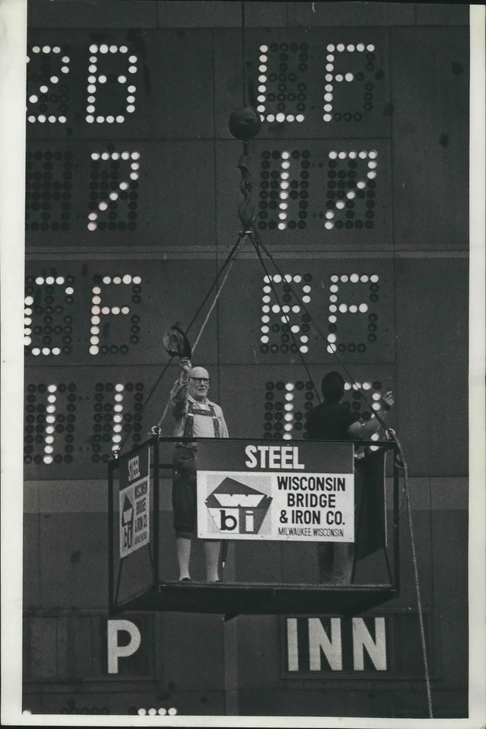 Bernie Brewer, actually Milton Mason, a 69 year old retired navy aviation engineer, waved to the fans Monday night as he was hoisted to the top of the scoreboard in County Stadium. Bernie vowed to stay in the trailer house atop the scoreboard until the Brewers drew a capacity crowd.