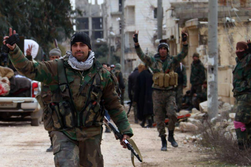 In this photo released Sunday, Feb. 16, 2020 by the Syrian official news agency SANA, Syrian army soldiers flash the victory sign in the Rashideen neighborhood, in Aleppo province, Syria. Syria's military announced on Monday that its troops have regained control of territories in northwestern Syria "in record time," vowing to continue to chase armed groups "wherever they are." (SANA via AP)