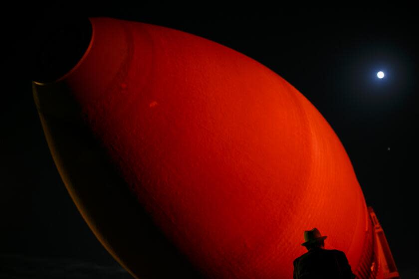 LOS ANGELES, CALIF. -- FRIDAY, MAY 20, 2016: A man takes a picture of the last shuttle fuel tank ET-94 before it begins it's journey along city streets to the California Science Center in Exposition Park, in Los Angeles, Calif., on May 20, 2016. (Marcus Yam / Los Angeles Times)