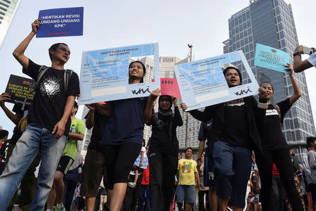 FILE PHOTO: Activists hold placards in the shape of national identity cards (KTP) during a protest calling for the investigation into alleged corruption linked to the procurement of the electronic cards by government officials in Jakarta, Indonesia March 19, 2017 in this photo taken by Antara Foto. Antara Foto/Hafiz Mubarak/via REUTERS