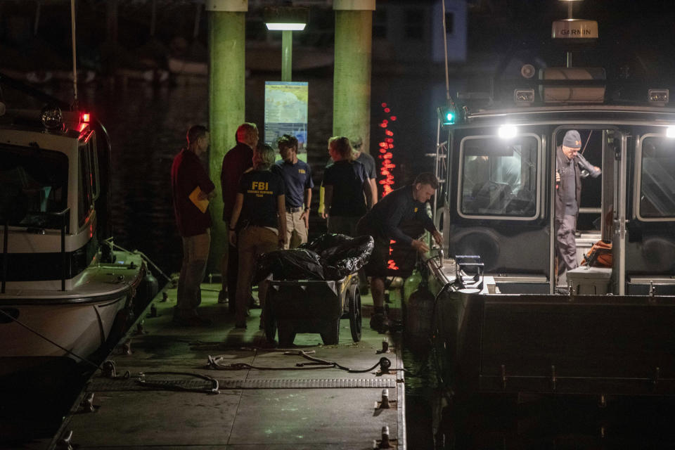 Authorities and FBI investigators cart away evidence taken from the scuba boat Conception in Santa Barbara Harbor at the end of their second day searching for the remaining divers still missing from the deadly pre-dawn fire on Tuesday, Sept. 3, 2019, in Santa Barbara, Calif. A fire raged through the boat Conception carrying recreational scuba divers anchored near an island off the Southern California Coast Monday, leaving multiple people dead. (AP Photo/Christian Monterrosa)