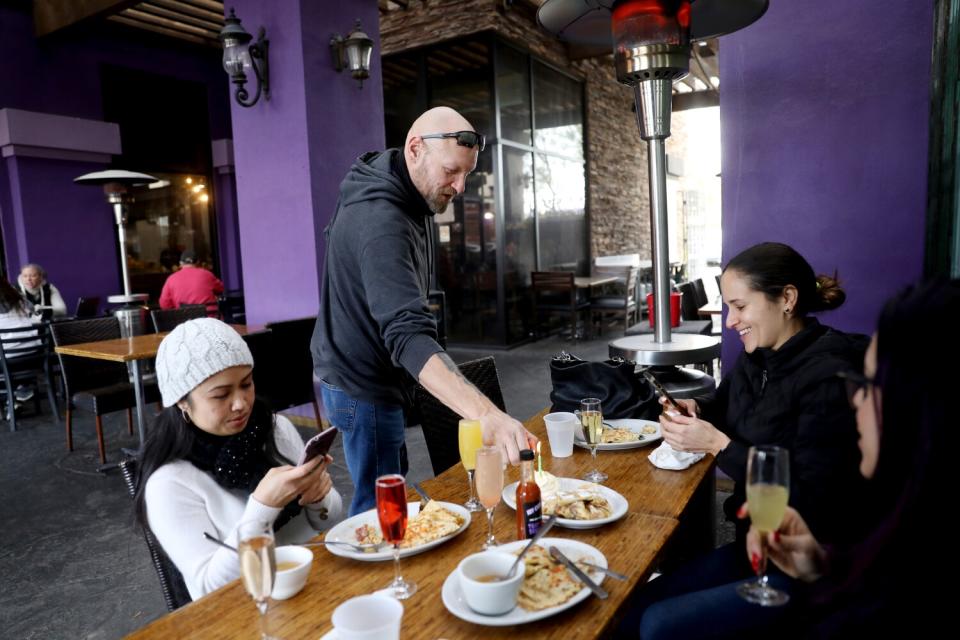 Lou Remillard waits on customers at his restaurant.