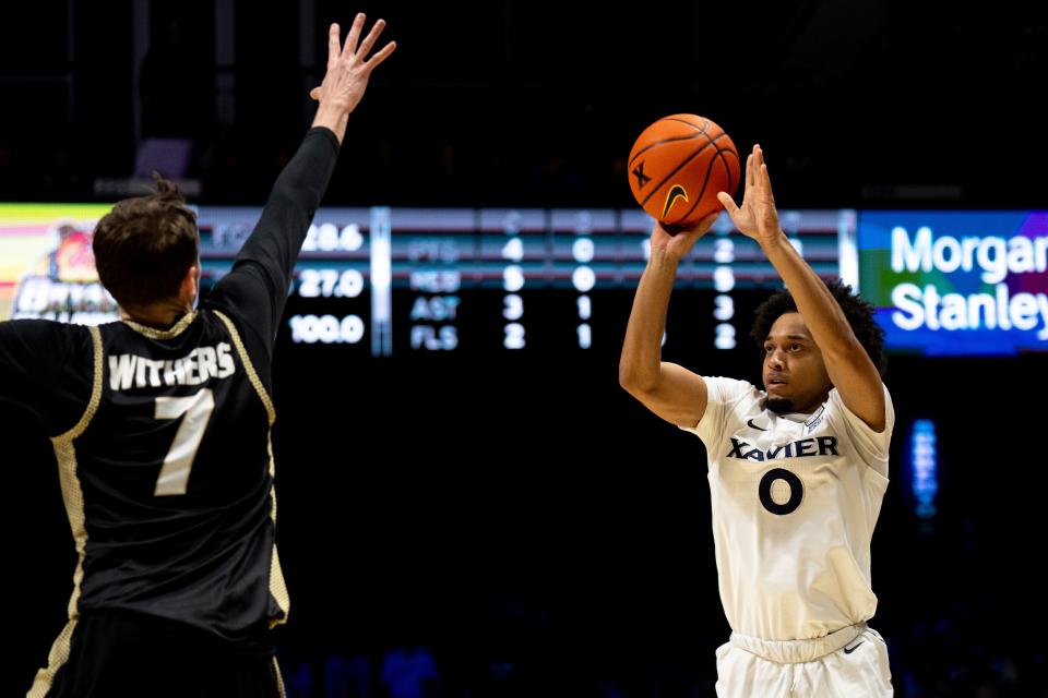 Xavier Musketeers guard Trey Green (0) hits a 3-point basket over Bryant Bulldogs forward Connor Withers (7) in the second half of the NCAA basketball game Bryant Bulldogs and Xavier Musketeers at Cintas Center in Cincinnati on Friday, Nov. 24, 2023.