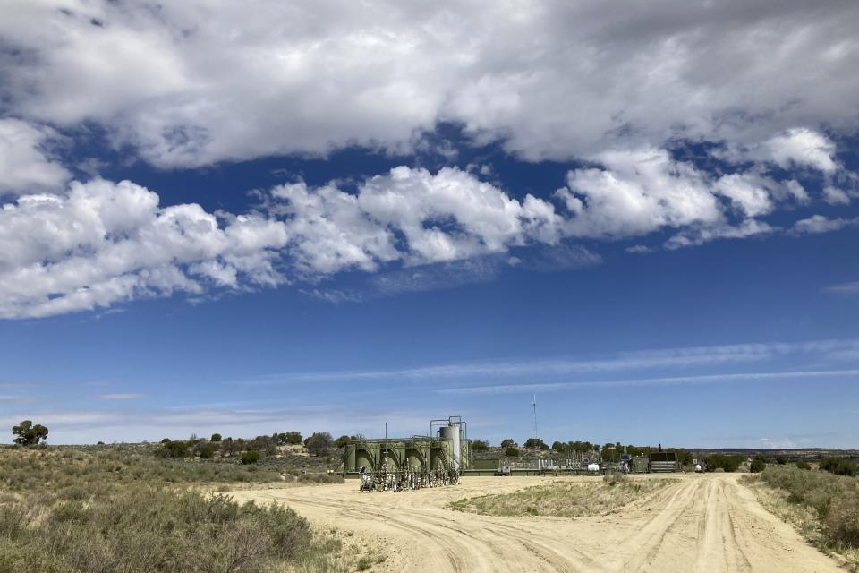 A well site stands across a highway from a school in Counselor, N.M., on May 17, 2023. On Thursday, June 1, 2023, New Mexico Land Commissioner Stephanie Garcia Richard issued an executive order that includes a ban on all new oil and gas leases on state trust land within a mile (1.6 kilometers) of schools or other educational institutions, including day care centers, preschools and sports facilities that students use. (AP Photo/Susan Montoya Bryan)
