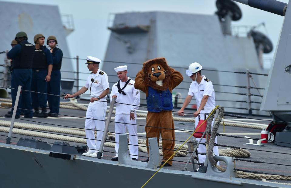 The USS Mason mascot, the Blue Lion, named after the ship's call sign, joins crew on deck as the ship is tied up at the pier upon arrival at Naval Station Mayport Monday morning.