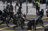 Riot police clash with protesters calling for electoral reforms and a boycott of the Chinese Communist Party in Hong Kong, Sunday, Jan. 19, 2020. Hong Kong has been wracked by often violent anti-government protests since June, although they have diminished considerably in scale following a landslide win by opposition candidates in races for district councilors late last year. (AP Photo/Ng Han Guan)