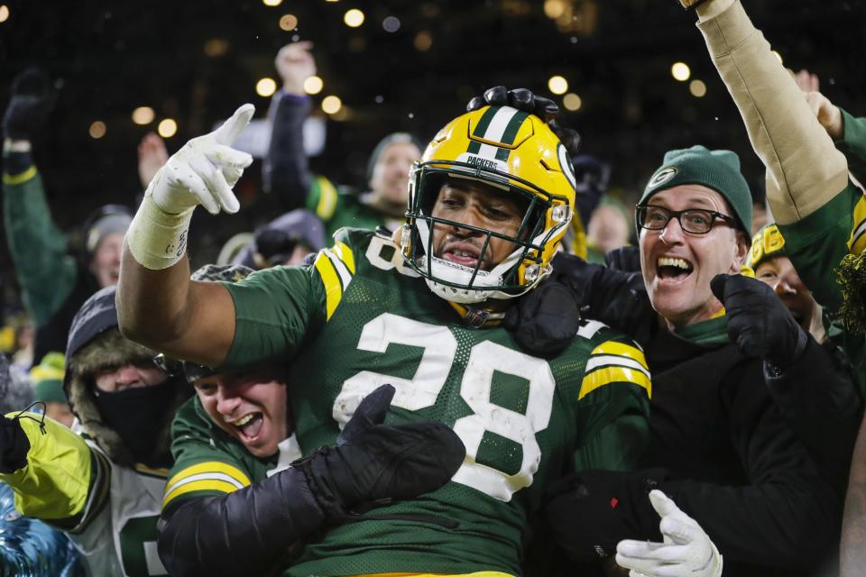 FILE - Green Bay Packers' AJ Dillon celebrates with fans after rushing for a touchdown during the second half of an NFL football game against the Seattle Seahawks, Sunday, Nov. 14, 2021, in Green Bay, Wis. Green Bay police say their internal affairs department is conducting a review after a video on social media showed an officer grabbing Packers running back A.J. Dillon during a Saturday night, July 23, 2022, soccer match at Lambeau Field. (AP Photo/Aaron Gash, File)