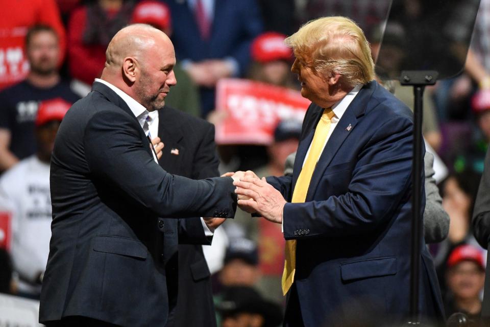 Dana White and Donald Trump shake hands at a political rally