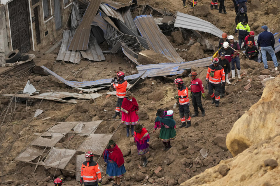 Rescue workers and residents walk amid the debris after a deadly landslide that buried dozens of homes in Alausi, Ecuador, Monday, March 27, 2023. (AP Photo/Dolores Ochoa)