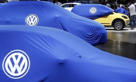 A man unveils a Volkswagen car during the International Sao Paulo Motor Show media day in Sao Paulo October 28, 2014. REUTERS/Paulo Whitaker