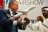 Boeing Commercial Airplanes president and CEO Stanley A. Deal, left, hands Sheikh Ahmed bin Saeed Al Maktoum, the chairman and CEO of the Dubai-based long-haul carrier Emirates, a model of a Boeing 787 Dreamliner at the Dubai Airshow in Dubai, United Arab Emirates, Wednesday, Nov. 20, 2019. Dubai's carrier Emirates announced Wednesday a firm order for 30 Boeing 787 Dreamliners in deal valued at $8.8 billion. (AP Photo/Jon Gambrell)