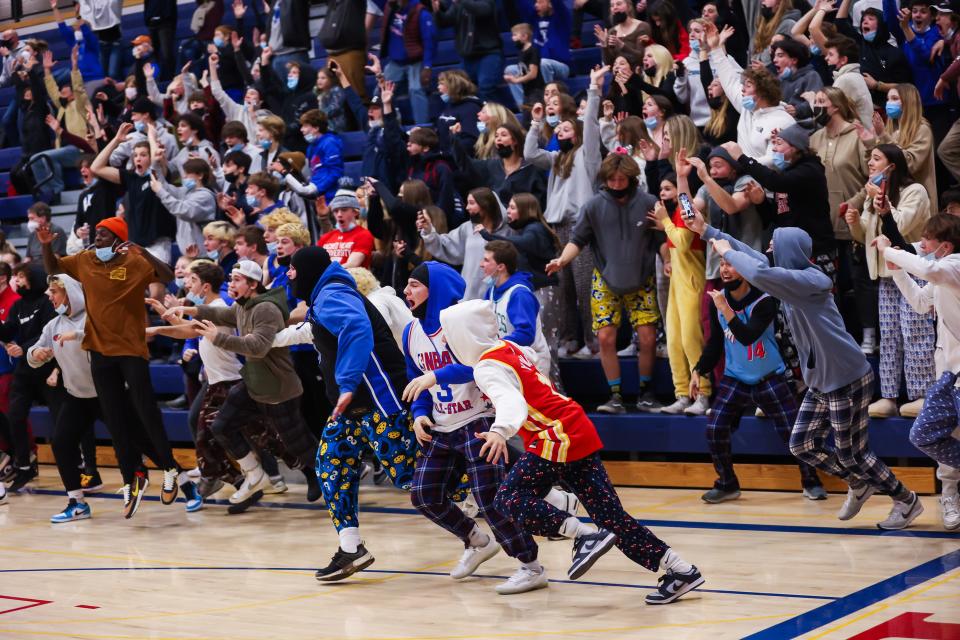 The Winnacunnet High School student section storms the floor after Josh Schaake hit a game-winning, buzzer-beating 3-pointer on Friday against Alvirne.