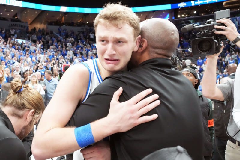 Star guard Tucker DeVries is hugged by a coach after Drake beat Indiana State in the Missouri Valley Conference title game to clinch a spot in the NCAA tournament Sunday at the Enterprise Center in St. Louis. Photo by Bill Greenblatt/UPI