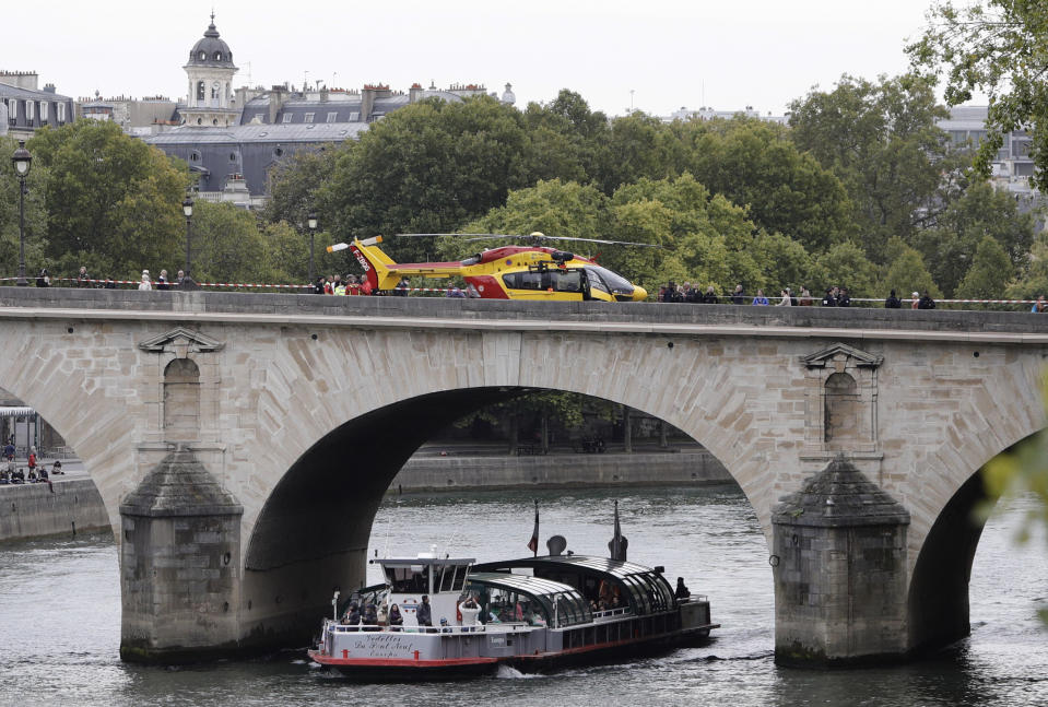 A helicopter is parked on the Pont Marie bridge after an incident at the police headquarters in Paris, Thursday, Oct. 3, 2019. A French police union official says an attacker armed with a knife has killed one officer inside Paris police headquarters before he was shot and killed. (AP Photo/Kamil Zihnioglu)