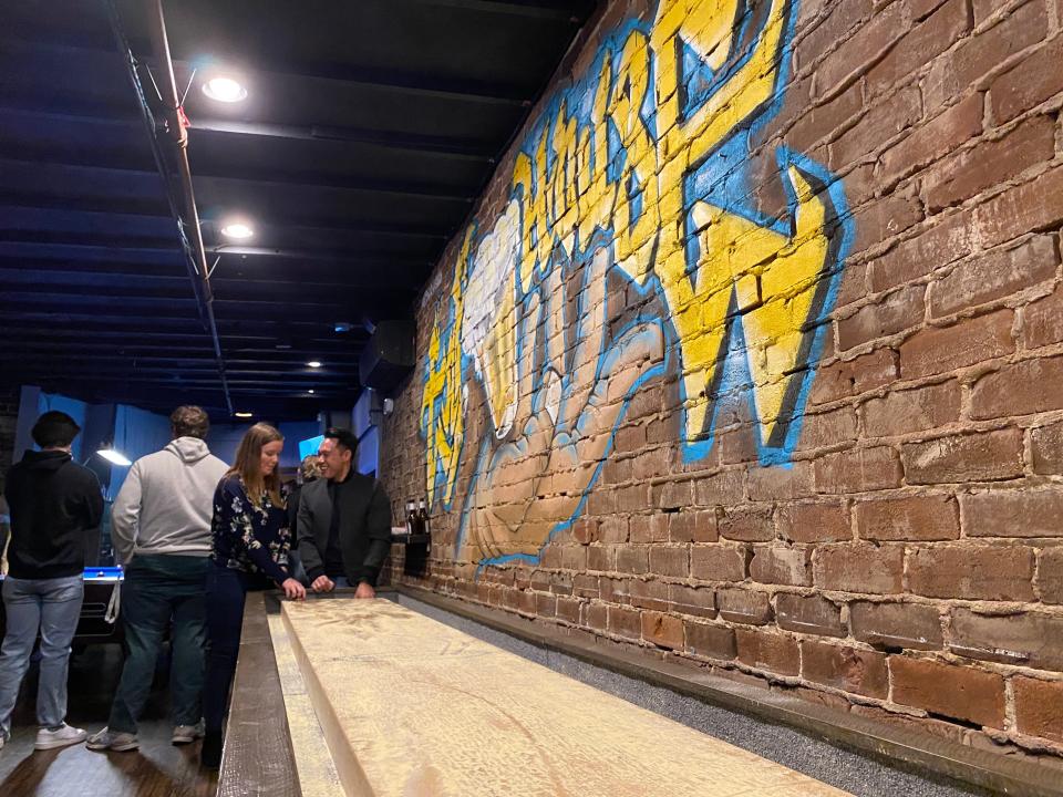 A blue-and-gold "Tap House" mural was added above a new full-size shuffleboard table in the middle room that connects Catherine Rooney's and Trolley Tap House in Wilmington.