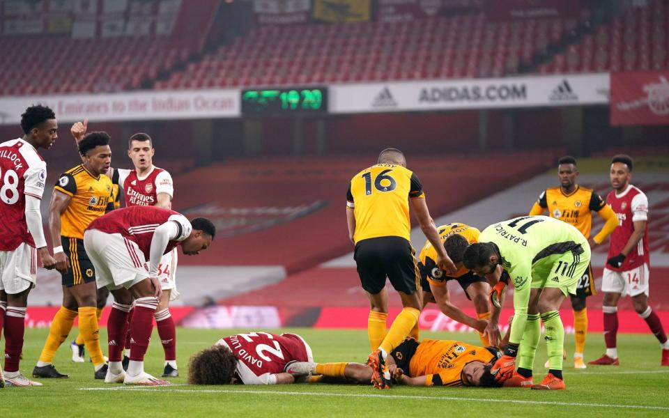 Players reacts after Arsenal's David Luiz (left, floor) clashes heads with Wolverhampton Wanderers' Raul Jimenez (right, floor) - Raul Jimenez to be discharged from hospital next week after Wolves forwards makes 'excellent progress' - PA