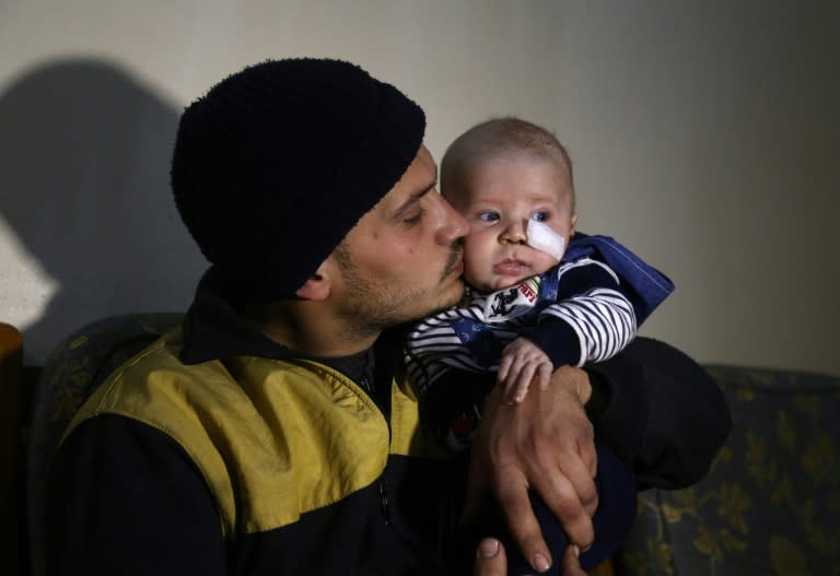 White Helmets member Saeed al-Masri holds his three-month-old son Yehya, who he rescued after a bombardment hit their home in Saqba