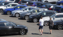 People view cars on the forecourt of a car sales outlet, in Norfolk, England, open for the first time since the lockdown, as part of a wider easing of restrictions in England, Monday June 1, 2020. The British government has lifted some lockdown restrictions to restart social life and activate the economy while still endeavouring to limit the spread of the highly contagious COVID-19 coronavirus. (Joe Giddens / PA via AP)